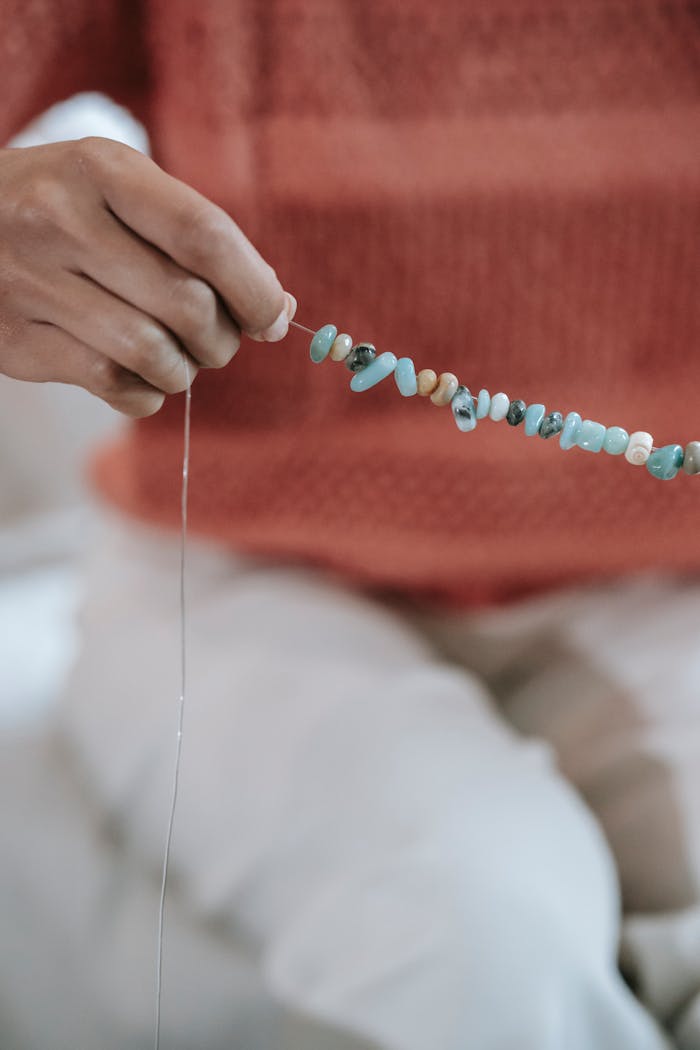 Close-up of a person stringing colorful beads for handmade jewelry creation.